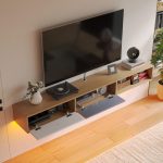 Eco-friendly floating TV console in natural wood with dual flip-down compartments for storage