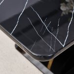 Black dining table with smooth marble grain surface and contemporary base