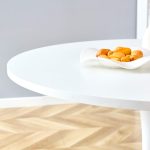 Contemporary white pedestal table styled with vase and books