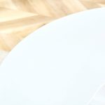 Modern white round table with single pedestal base in minimalist living room